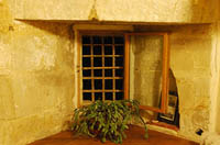 The medieval windows had bars and shutters, but no glass. The frame here is new.
